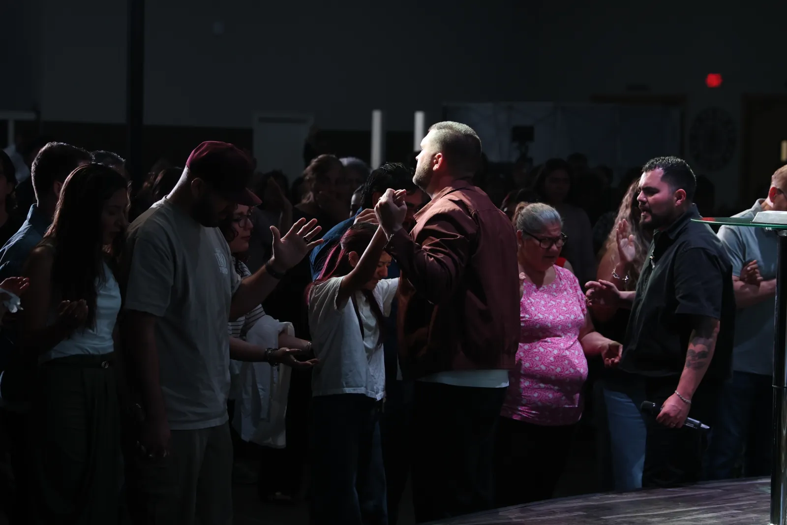 Personas orando juntas en Iglesia Nuevo Pacto